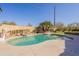 Backyard pool featuring a waterfall, palm trees, and a basketball hoop at 3524 E Derringer Way, Gilbert, AZ 85297