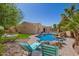 Relaxing poolside scene with cozy loungers, rock waterfall, and a sparkling pool for ultimate comfort at 3562 E Harvard Ct, Gilbert, AZ 85234