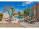 Lush pool area with lounge chairs, tables, and umbrellas on a sunny day at 3562 E Harvard Ct, Gilbert, AZ 85234