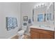 Well-lit bathroom with wood vanity, and neutral-toned tile flooring at 366 E Mule Train Trl, San Tan Valley, AZ 85143