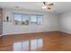 Large bedroom features wood floors, two windows, ceiling fan, and a gray accent wall at 366 E Mule Train Trl, San Tan Valley, AZ 85143