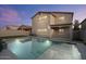 Backyard view of a refreshing pool and covered patio at dusk at 366 E Mule Train Trl, San Tan Valley, AZ 85143