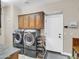 Laundry room featuring gray front load machines and wood cabinets at 4122 E Burnside Trl, Cave Creek, AZ 85331