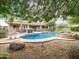 Beautiful backyard pool featuring rock accents and a spa, surrounded by lush landscaping and mature trees at 4122 E Burnside Trl, Cave Creek, AZ 85331