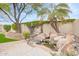 Serene backyard featuring a rock waterfall, lush greenery, and mature palm trees at 44 W Teakwood Pl, Chandler, AZ 85248