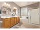 Bathroom featuring double sinks, soaking tub, glass block window, and tiled floor at 44 W Teakwood Pl, Chandler, AZ 85248