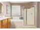 Bathroom featuring double sinks, soaking tub, glass block window, and glass-enclosed shower at 44 W Teakwood Pl, Chandler, AZ 85248