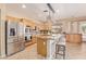 Well-lit kitchen featuring stainless steel appliances, granite countertops, island and light brown wood cabinetry at 44 W Teakwood Pl, Chandler, AZ 85248