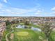 Scenic aerial view of the golf course community featuring lush greens, mature trees, and picturesque lake at 4720 E Flossmoor Cir, Mesa, AZ 85206