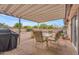 Covered backyard patio has dining table, chairs, and grill, perfect for outdoor entertainment at 4720 E Flossmoor Cir, Mesa, AZ 85206