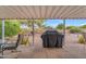 Backyard patio with shaded awning, BBQ grill, and well-maintained desert landscape at 4720 E Flossmoor Cir, Mesa, AZ 85206