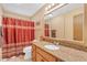 Well-lit bathroom features granite countertops, a large mirror, and a shower with a curtain for modern comfort and style at 4720 E Flossmoor Cir, Mesa, AZ 85206