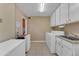 Functional laundry room with white appliances, cabinets, and tile flooring for ease of cleaning at 4720 E Flossmoor Cir, Mesa, AZ 85206