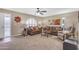 Comfortable living room with neutral carpet, ceiling fan, and a large window for natural light at 4720 E Flossmoor Cir, Mesa, AZ 85206