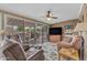 Cozy living room with sliding glass doors to the patio and brick accent wall with flatscreen TV at 4720 E Flossmoor Cir, Mesa, AZ 85206