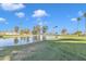 Picturesque view of the pond on the golf course, featuring a fountain, lush green grass, and mature trees at 4720 E Flossmoor Cir, Mesa, AZ 85206