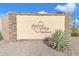 Community sign for Sunland Village 55+ community, set against a backdrop of gravel and desert plants at 4720 E Flossmoor Cir, Mesa, AZ 85206