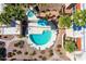 Aerial view of the community pool featuring a hot tub, lounge chairs, desert landscaping and manicured palm trees at 4950 N Miller Rd # 231, Scottsdale, AZ 85251