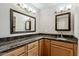 Well-lit bathroom with dual sinks, granite counters and framed mirrors at 4950 N Miller Rd # 231, Scottsdale, AZ 85251