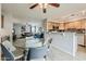 Open concept living area featuring a glass table, view to the living room, and wooden cabinets with black backsplash at 4950 N Miller Rd # 231, Scottsdale, AZ 85251