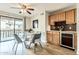 Dining area with glass table, modern chairs, wood flooring, alongside a cabinet with a bar area and sliding glass doors at 4950 N Miller Rd # 231, Scottsdale, AZ 85251