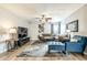 A modern living room featuring a gray sofa, blue arm chair, media center, ceiling fan, with a large art piece on the wall at 4950 N Miller Rd # 231, Scottsdale, AZ 85251