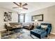 Bright living room with a comfortable gray sectional, blue accent chair, decorative rug, ceiling fan, and a large wall mirror at 4950 N Miller Rd # 231, Scottsdale, AZ 85251