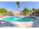 Exterior shot of the inviting community pool surrounded by lush palm trees, lounge chairs and desert landscaping at 4950 N Miller Rd # 231, Scottsdale, AZ 85251