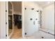 Stylish bathroom featuring a modern glass shower and doorway leading to a custom walk-in closet at 510 E Woburn Ln, Phoenix, AZ 85085