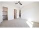 A minimalist bedroom featuring neutral carpet, ceiling fan, closet, and ensuite bathroom at 510 E Woburn Ln, Phoenix, AZ 85085