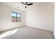 Minimalist bedroom with neutral carpet, a window, ceiling fan, and white walls at 510 E Woburn Ln, Phoenix, AZ 85085