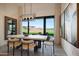 Formal dining room with view of backyard, modern light fixture and luxury finishes at 510 E Woburn Ln, Phoenix, AZ 85085