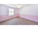 Bedroom featuring soft pink accents, a window, and neutral carpeting at 5501 E Camelback Rd, Phoenix, AZ 85018