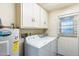 Laundry room with washer, dryer, a water heater and cabinets above creating an efficient utility area at 5501 E Camelback Rd, Phoenix, AZ 85018