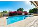 Backyard pool surrounded by lush greenery, flowers, and trees, creating a serene outdoor escape at 5501 E Camelback Rd, Phoenix, AZ 85018