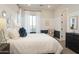 This bedroom features a large window with sheer white curtains, an accent chair, and blue and white walls at 5508 N 192Nd Ave, Litchfield Park, AZ 85340