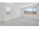 Bright bedroom featuring neutral carpet, white walls and trim, and two windows providing ample natural light at 5508 N 192Nd Ave, Litchfield Park, AZ 85340