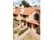 Aerial view of tan townhomes with tile roofs, decorative pillars, manicured landscaping, and address numbers at 5704 E Aire Libre Ave # 1044, Scottsdale, AZ 85254