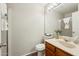 Bright bathroom with a white toilet and shower, a wood vanity, a large mirror and a four-light fixture at 5704 E Aire Libre Ave # 1044, Scottsdale, AZ 85254