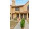 Charming tan townhome with tile roof, decorative pillars, manicured landscaping, and address numbers at 5704 E Aire Libre Ave # 1044, Scottsdale, AZ 85254