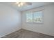 A vacant and carpeted bedroom with ample light from the window at 5853 E Thomas Rd, Scottsdale, AZ 85251