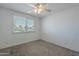 Neutral carpeted bedroom featuring a ceiling fan and a window at 5853 E Thomas Rd, Scottsdale, AZ 85251