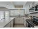 Modern kitchen with stainless steel appliances, white cabinets, and ample quartz countertops at 5853 E Thomas Rd, Scottsdale, AZ 85251