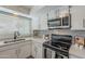 Updated kitchen with stainless steel appliances, white cabinetry, and stylish backsplash at 5853 E Thomas Rd, Scottsdale, AZ 85251