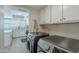 A modern laundry room features stainless steel washer and dryer and easy access to the kitchen with white cabinets at 5853 E Thomas Rd, Scottsdale, AZ 85251