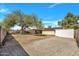 Spacious backyard featuring mature trees and block fencing and a paved seating area at 635 W Pecos Ave, Mesa, AZ 85210