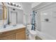 Well-lit bathroom with a shower and tub combination, vanity, and neutral decor creating a clean feel at 635 W Pecos Ave, Mesa, AZ 85210