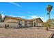 Single-story home showcasing desert landscaping, a covered carport, and desert rock landscaping underneath a bright blue sky at 635 W Pecos Ave, Mesa, AZ 85210