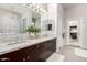 Bright bathroom featuring marble counters, dual sinks, soaking tub, glass enclosed shower, and neutral color scheme at 7525 E Gainey Ranch Rd # 110, Scottsdale, AZ 85258