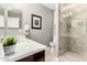 Well-lit bathroom with a modern sink, tiled shower, and decorative wall art at 7525 E Gainey Ranch Rd # 110, Scottsdale, AZ 85258